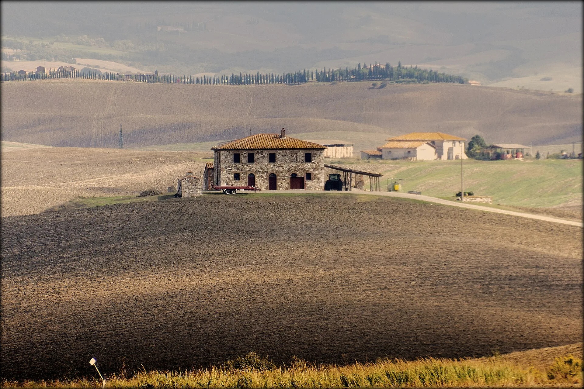 A stone farmhouse among cypress trees in the Tuscan countryside, Italy