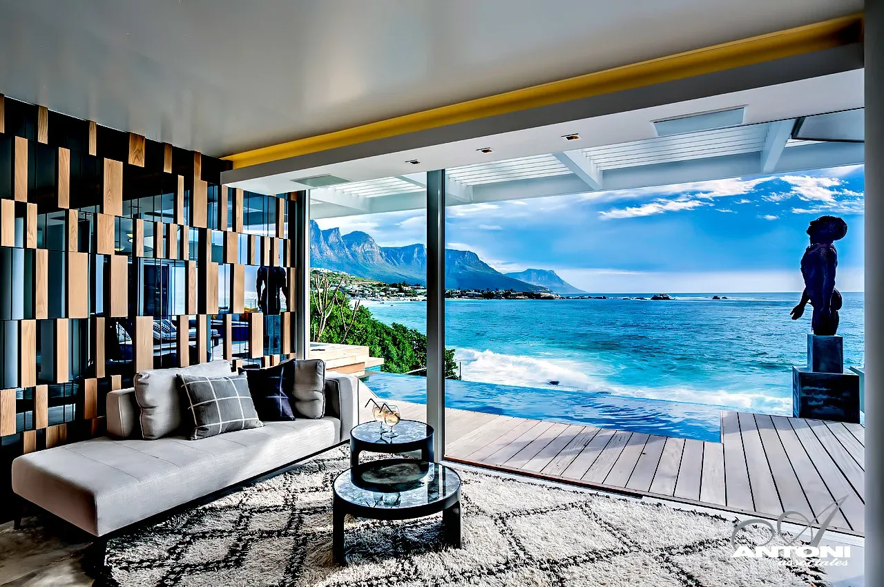 Cape Town apartment living room with floor-to-ceiling glass framing the Twelve Apostles mountains and the Atlantic Ocean