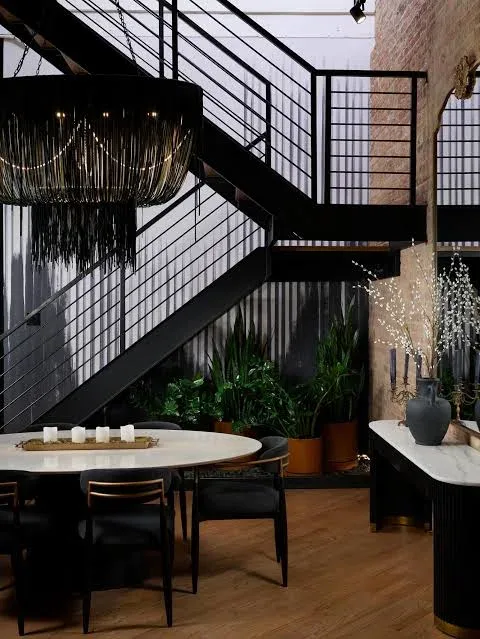 Stylish Chicago loft interior with exposed brick, a black steel staircase and a designer dining room