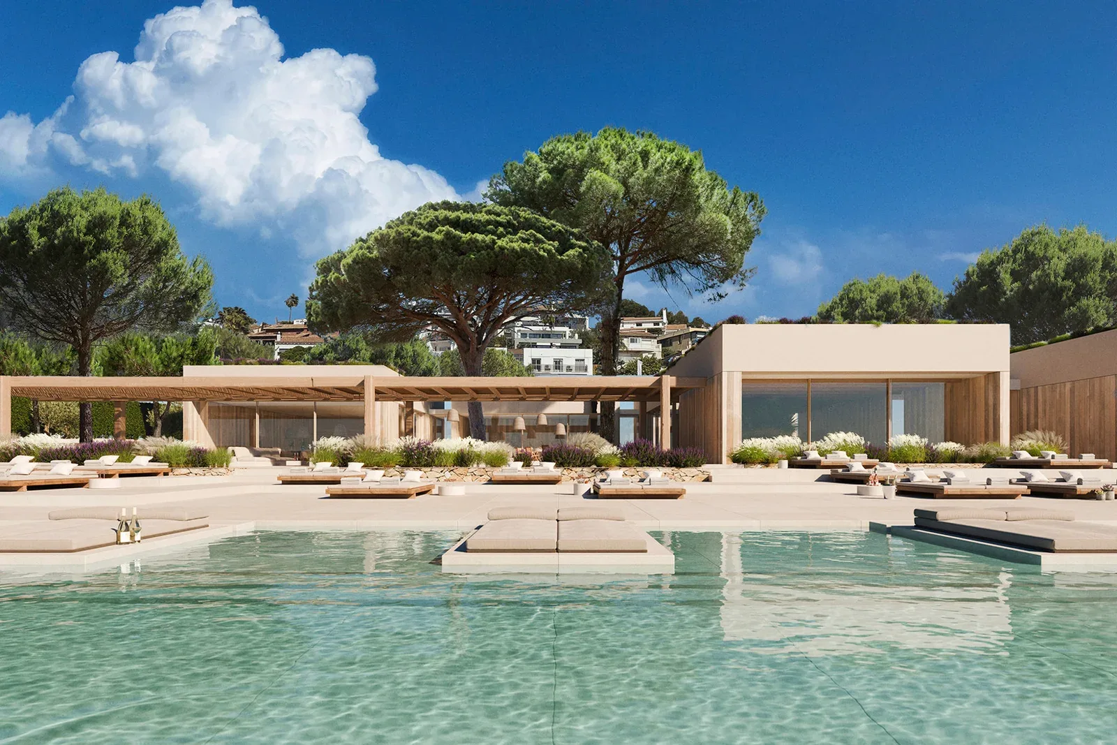 Minimalist modern beige and wood villa with a large swimming pool and Mediterranean umbrella pine trees on a hillside above Sitges, Spain