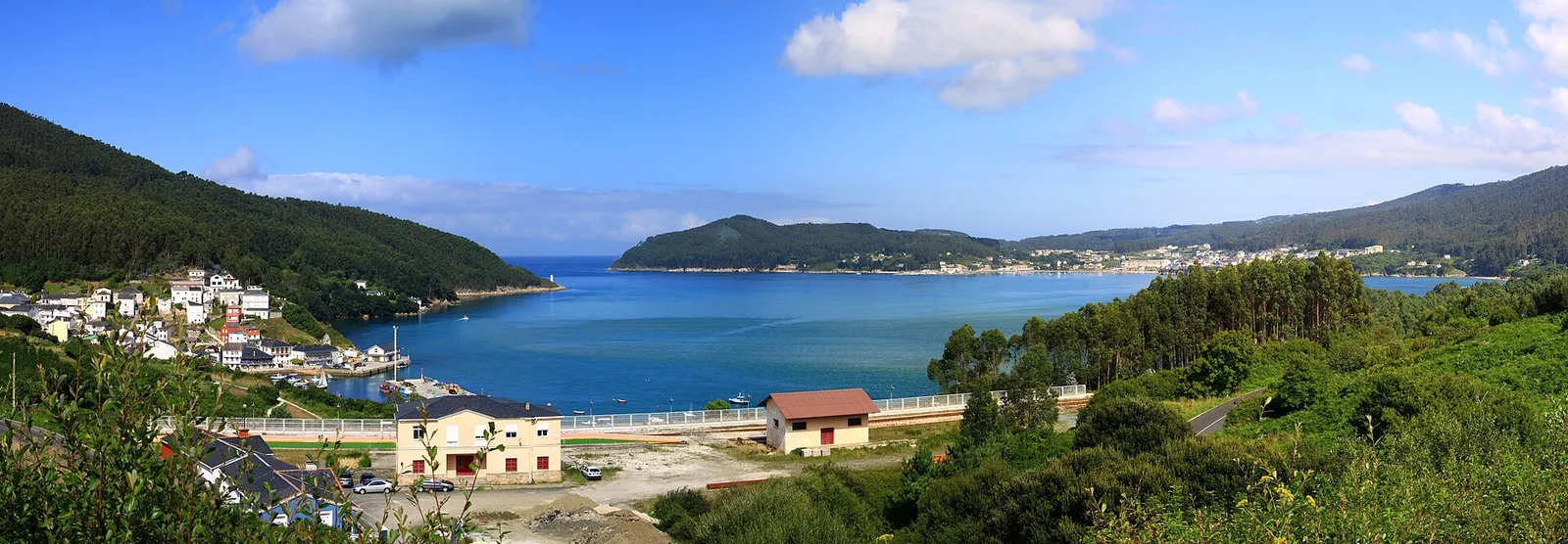 A green estuary and rolling coastal hills at O Barqueiro in Galicia, Spain
