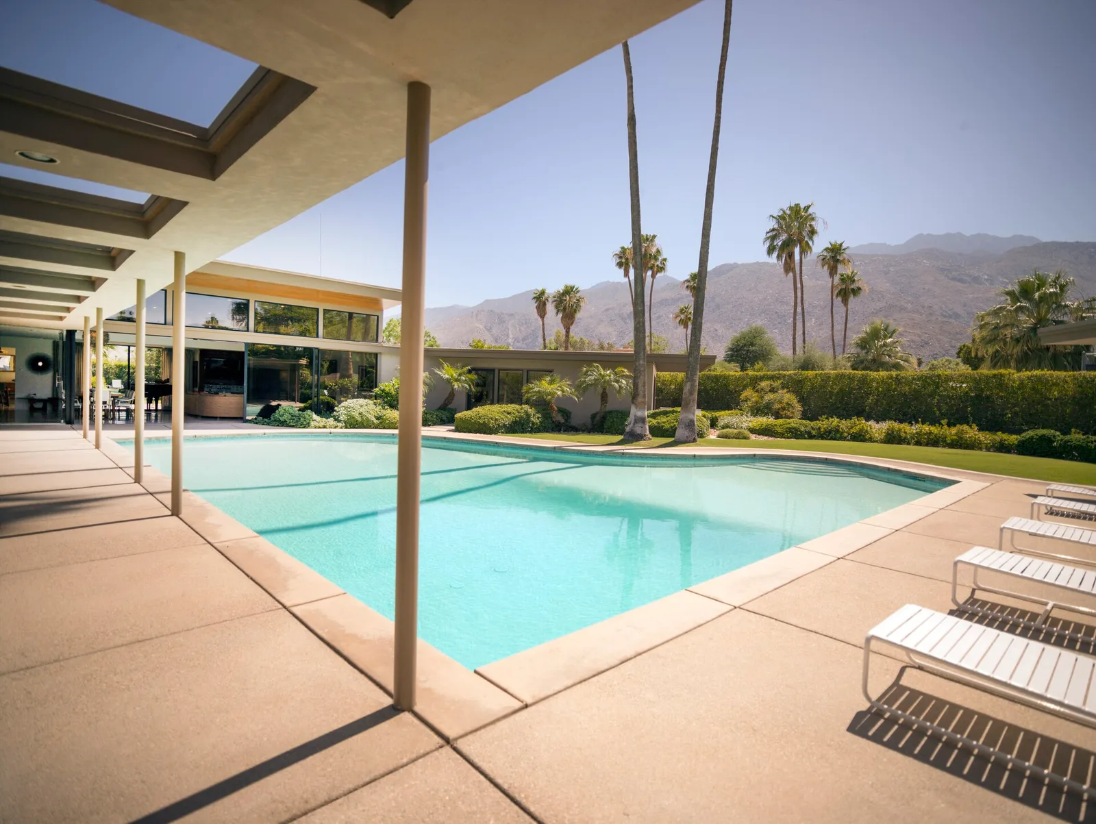 A mid-century modern desert home with a pool and mountains behind in the Palm Springs area, California