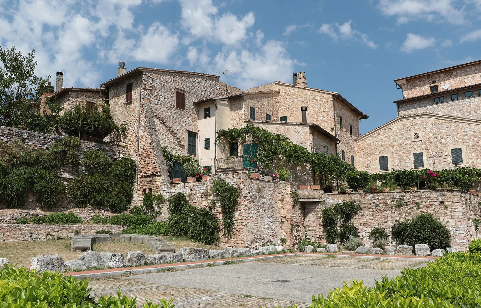 Stacked stone houses climbing the hillside of the medieval town of Spello in Umbria, Italy